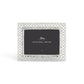 The Michael Aram Love Knot Silver Frame Collection features a decorative silver frame with an intricate lattice design, symbolizing unity, and includes a 5x7 placeholder card.