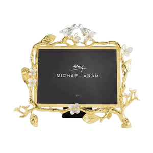 The Lovebirds Frame Collection by Michael Aram features a gold and silver picture frame adorned with floral and branch motifs, topped with two charming birds and finished with a black insert—making it an ideal choice for an elegant wedding or timeless anniversary gift.