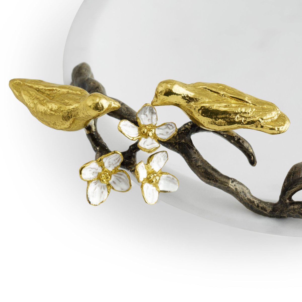 The Michael Aram Lovebirds Trinket Dish features two gold birds perched on a branch with white and gold flowers, creating an elegant Tree of Life design—perfect as a jewelry holder or decorative accent.