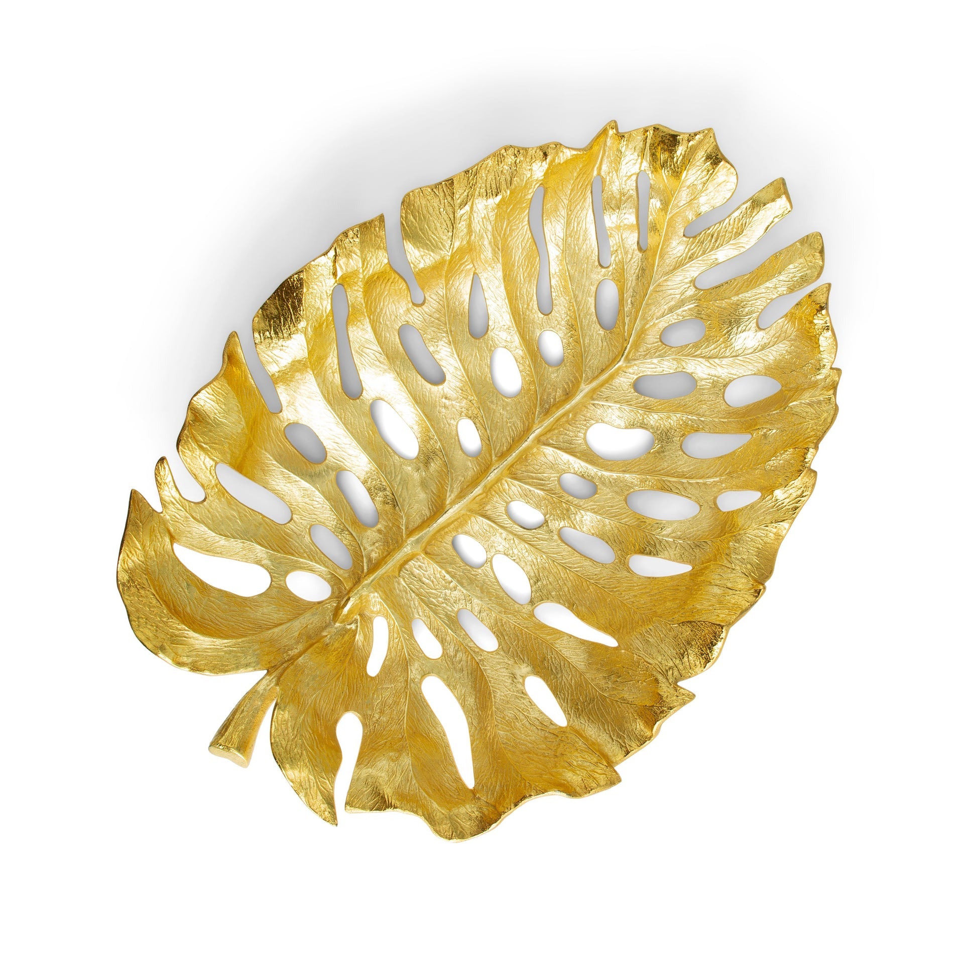 The Michael Aram New Leaves Serveware Collection features a gold tray shaped like a Monstera leaf, inspired by nature, and photographed on a white background.