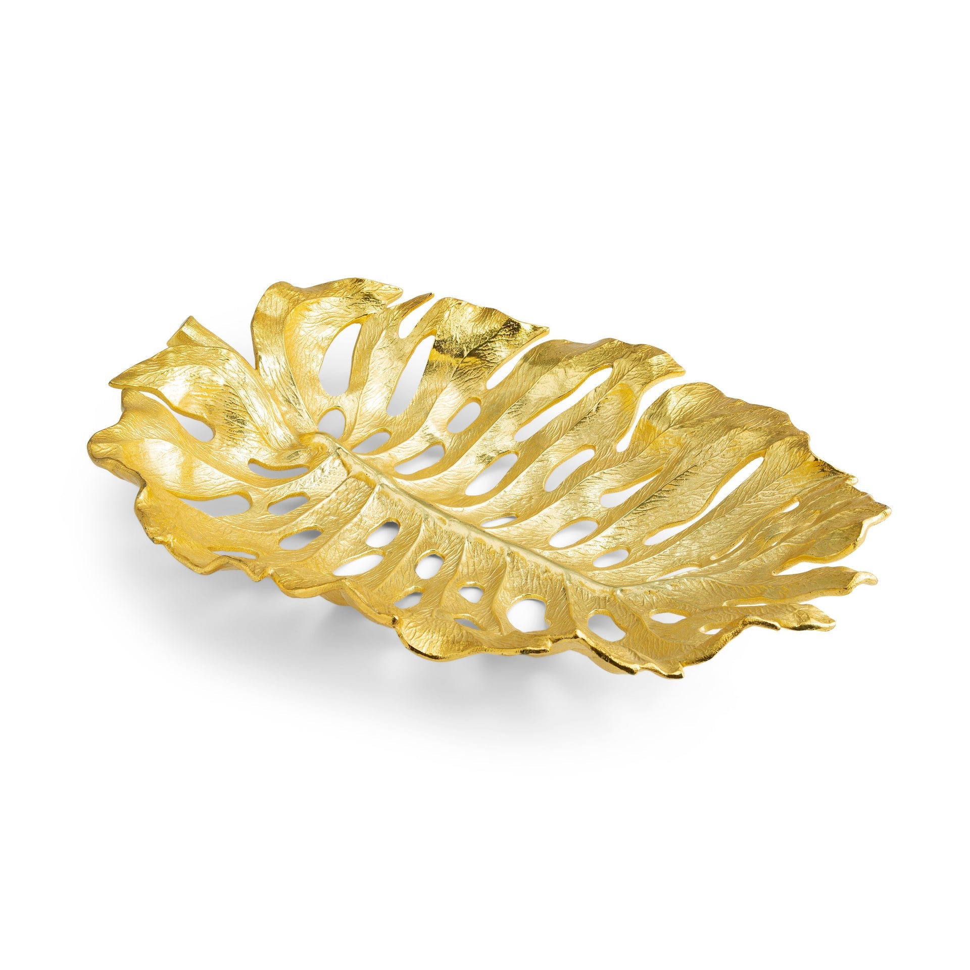 The Michael Aram New Leaves Serveware Collection features a gold monstera leaf decorative tray with detailed texture and cut-out sections, blending handcrafted, nature-inspired design with functional art.