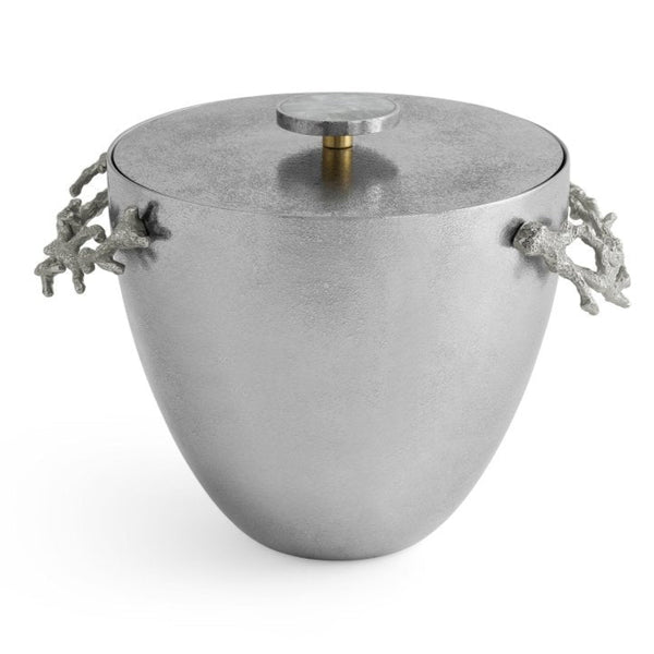 The Michael Aram Ocean Reef Ice Bucket, part of the Ocean Reef Collection, features a round lid and coral-shaped handles. Made from hand-textured stainless steel, it exudes coastal elegance.