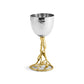 A silver hammered metal goblet from Michael Aram’s Olive Branch Judaica Collection with a gold, vine-inspired stem and base stands upright against a white background.