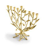 A gold menorah from Michael Aram’s Olive Branch Judaica Collection, designed to resemble a tree with branches, leaves, eight candle holders, and one central holder.