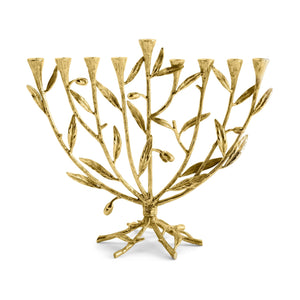 A gold menorah from Michael Aram's Olive Branch Judaica Collection, inspired by olive branches and leaves, features eight candle holders in a row with a ninth elevated holder at the center.