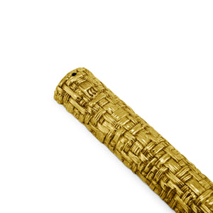 The Palm Mezuzah by Michael Aram is a gold textured cylindrical object with an antique gold finish and sculpted textures, featuring a woven basket-like pattern, positioned diagonally on a white background.