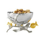 A silver bowl of the Michael Aram Pomegranate Silver & Gold Serveware Collection rests on a decorative branch stand, crafted in stainless steel, nickelplate, and goldplate.