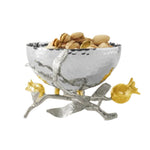 A silver bowl of the Michael Aram Pomegranate Silver & Gold Serveware Collection rests on a decorative branch stand, crafted in stainless steel, nickelplate, and goldplate.