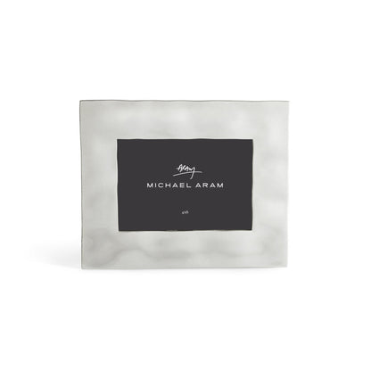 The Michael Aram Reflective Frame Nickel Collection is a square, silver-toned picture frame with a simple brushed finish and a brand-name placeholder insert.