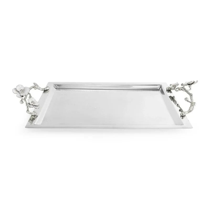 Inspired by the purity and grace of the orchid plant, the Silver Orchid Collection by Michael Aram features this rectangular silver serving tray with raised edges and decorative handles resembling flowering branches on each end. This elegant piece brings refined beauty to any table setting.