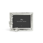 Silver rectangular photo frame from Michael Aram’s White Orchid Frame Collection, featuring a hammered texture and orchid-inspired floral accents on the lower left corner, with “Michael Aram” placeholder displayed.