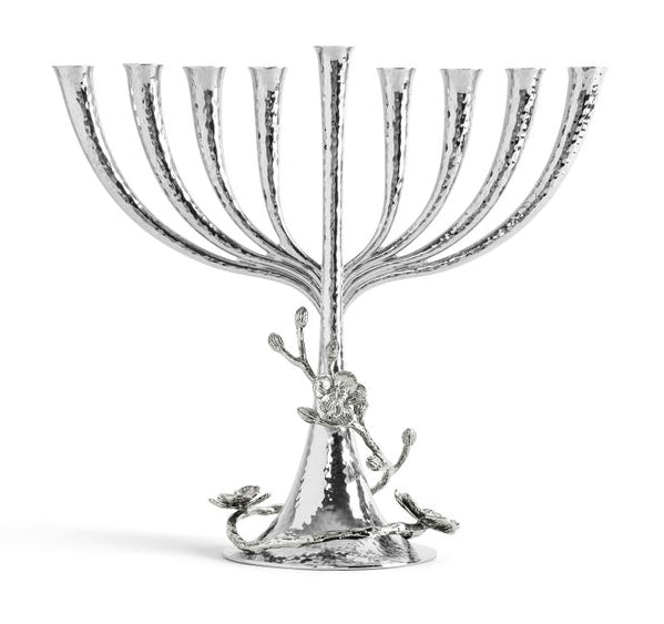 The Michael Aram White Orchid Menorah features a handcrafted nickelplate design with eight branches, a central stem, hammered texture, and elegant floral accents on the base.