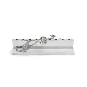 Rectangular silver pen holder from the Michael Aram White Orchid Judaica Collection, featuring a textured surface with black dots and an elegant flower and branch motif on the front.