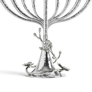 Close-up of the base of the Michael Aram White Orchid Menorah, featuring a hammered texture and adorned with detailed flower and branch motifs.