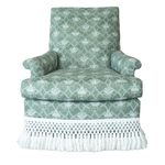 The Virginia Skirted Swivel Chair by Hickory Chair features green upholstery with white floral patterns, a skirt adorned with a lattice design, mahogany front posts, and long white fringe along the bottom.