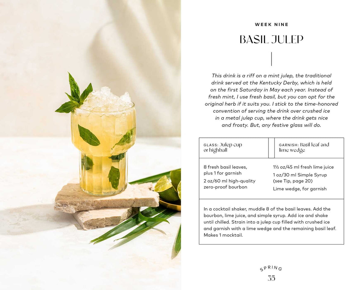 A glass of Monday Night Mocktails by Simon & Schuster, garnished with ice, fresh basil leaves, and a lime wedge, sits on a white surface; scattered basil and lime nearby make it an appealing and refreshing option for those interested in non-alcoholic drinks or innovative mocktail recipes.
