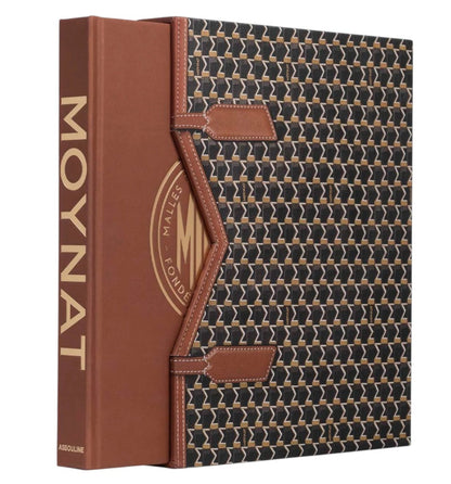 “Moynat” by Assouline is a book with a brown spine and a patterned slipcase, celebrating iconic French luxury leather goods like travel accessories and wardrobe trunks.