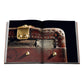 Open book featuring a close-up of a vintage Moynat leather trunk, an iconic French luxury piece, with metal nameplate, brass studs, and textured details. Published by Assouline.