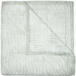 Expertly hand quilted from soft cotton voile, the Nandi Bedding Collection by John Robshaw features a folded light quilt with thin, horizontal green stripes and a corner turned down to reveal an underside with matching stripes, offering a lightweight and luxurious feel.