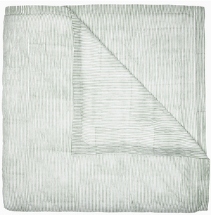 Expertly hand quilted from soft cotton voile, the Nandi Bedding Collection by John Robshaw features a folded light quilt with thin, horizontal green stripes and a corner turned down to reveal an underside with matching stripes, offering a lightweight and luxurious feel.