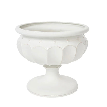 The Juliska Large Whitewashed Decorative Urn features a pedestal design with scalloped patterns and circular accents, making it an elegant centerpiece or a stylish addition to your formal garden décor.