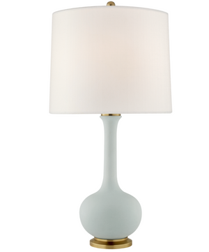 The Visual Comfort Coy Medium Table Lamp features a matte sky blue ceramic base inspired by classical forms, a white drum shade, and refined brass accents on the top and bottom.