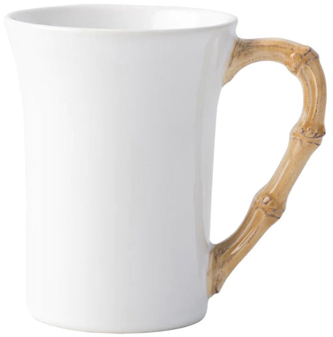 A white ceramic mug from Juliska’s Classic Bamboo Dinnerware Collection featuring a bamboo-inspired handle for casual elegance and global flair at your table.