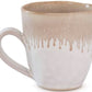 The Burlington Bluff Dinnerware Collection by Simon Pearce features a ceramic mug with a round handle and beige Bluff glaze drip near the rim on a white base, inspired by classic pinch-pot designs.
