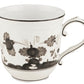 The Ginori 1735 Oriente Italiano Albus Dinnerware Collection features a white ceramic mug with a black Florentine Maison floral pattern and curved handle, inspired by classic designs, shown against a plain white background.