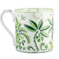 The Cobblers Cove Calypso Dinnerware Collection by Royal Crown Derby features a white ceramic mug adorned with green botanical and jungle motifs, bringing a lively Caribbean feel to your vibrant green dinnerware ensemble.