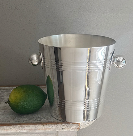 The Hôtel Silver Vintage Ice Bucket with Ball Handles, featuring classic clean lines and a shiny silver finish, sits beside a whole lime, evoking timeless hotel silver serve ware.