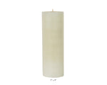 A Perin Mowen Solid Pillar Candle Collection piece—a tall white beeswax candle (3" diameter, 9" height)—is shown against a plain white background, showcasing the warm glow of natural candlelight.
