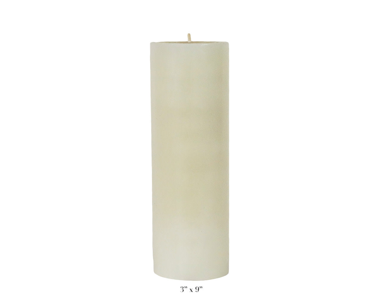 A Perin Mowen Solid Pillar Candle Collection piece—a tall white beeswax candle (3" diameter, 9" height)—is shown against a plain white background, showcasing the warm glow of natural candlelight.