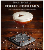 A martini glass filled with a frothy espresso martini, topped with coffee beans, rests on a slate coaster while scattered coffee beans decorate the wooden table nearby. Featured is the book “The Art & Craft of Coffee Cocktails” from Simon & Schuster.