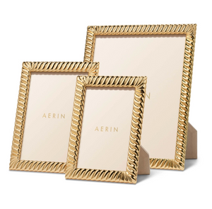 Three gold Loretta frames by Aerin, each with a twist design border, stand upright on a white background. Elegant placeholders display "AERIN," showcasing the refined style of this frame collection.