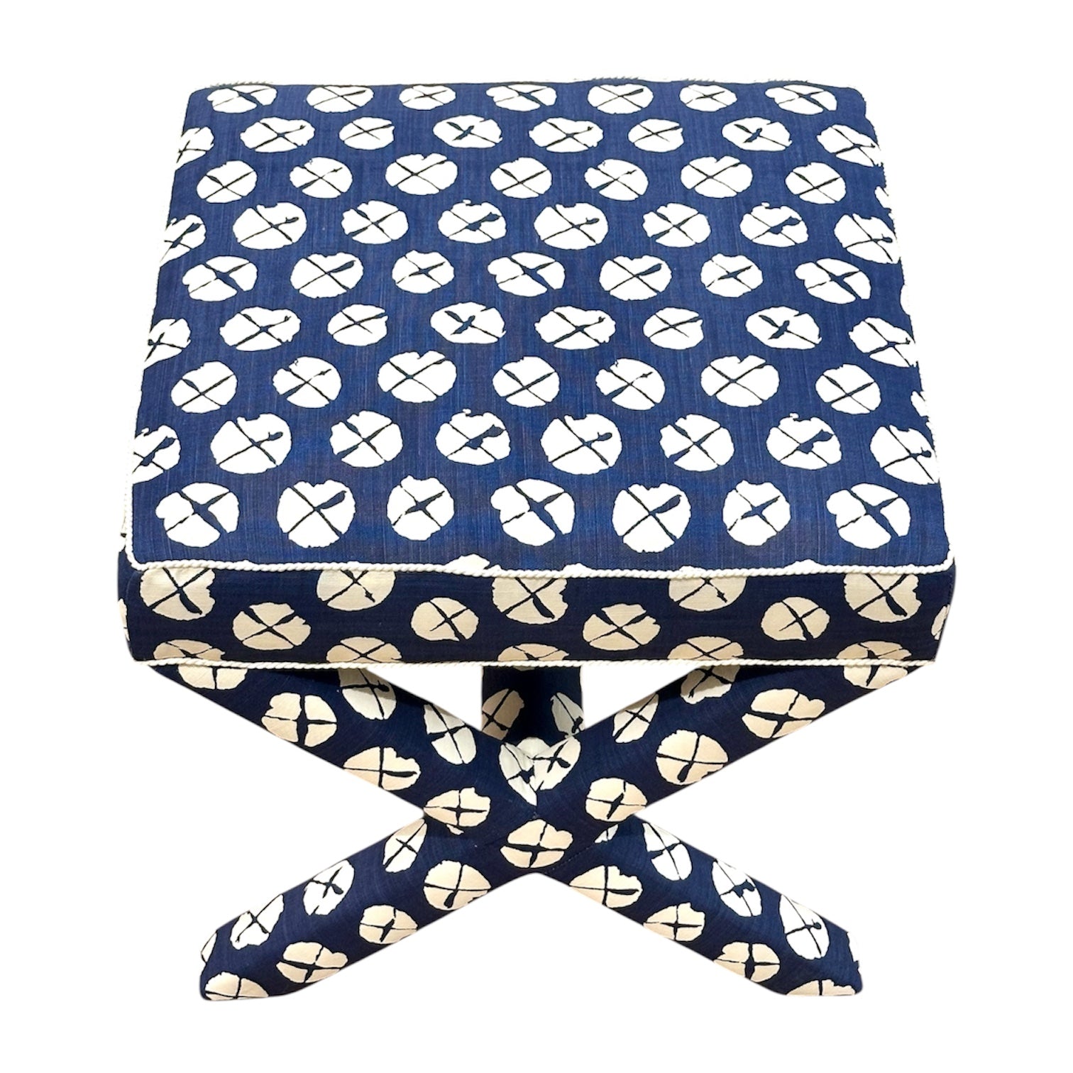 The Lee Industries X Ottoman features blue and white circular patterned upholstery and matching crossed legs, perfect for accent seating.