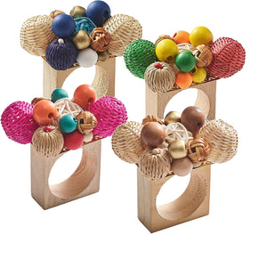 The Kim Seybert Java Napkin Ring features wooden beads, colorful balls, and woven rattan clustered atop each ring for a vibrant, artisanal touch.