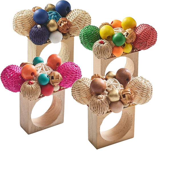 Three vibrant Kim Seybert Java Napkin Rings, handcrafted from wood and decorated with woven and wooden beads in an array of colors—blue, green, pink, orange, and gold—are showcased vertically.