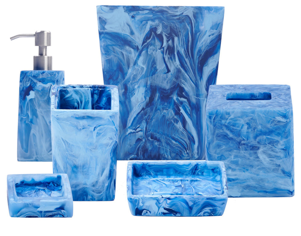 The Denim Resin Bath Collection by Nashi Home features blue and white marbled bathroom accessories inspired by Sydney beaches, including a soap dispenser, toothbrush holder, tissue box, waste bin, soap dish, and tray.