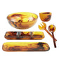 The Tortoise Resin Serveware Collection by Nashi Home features amber and brown marbled serving pieces—large bowl, small bowl, divided tray, platter, and salad utensils—that are stylish, shatter resistant, and perfect for daily use.