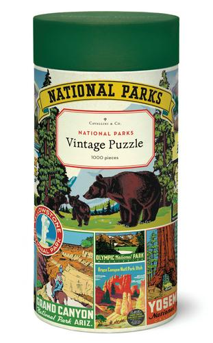 A cylindrical box labeled "Cavallini & Co. National Parks Map 1,000 Piece Puzzle," from Cavallini Papers and Co, contains a puzzle featuring illustrated scenes from various national parks, including bears and park posters. This charming collection is inspired by the Cavallini archives, offering a nostalgic journey through nature's finest.