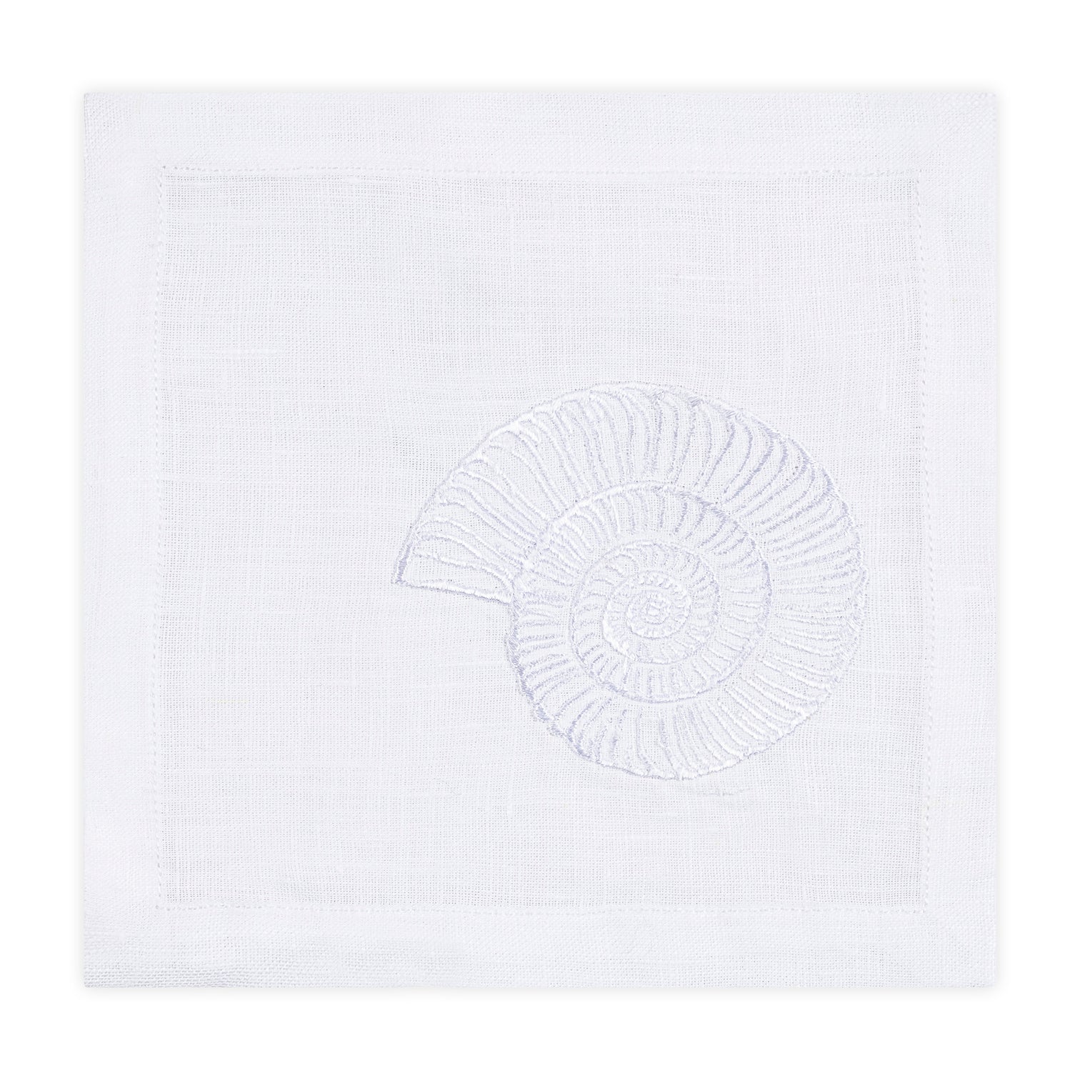 The Nautilus Shell Coaster Set by Haute Home features white linen coasters embroidered with a nautilus shell design, ideal for bringing coastal elegance to your table setting.
