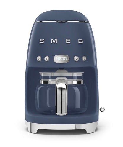 A blue Smeg Drip Filter Coffee Machine Collection with a glass carafe, digital display, reusable filter, and silver accents sits against a white background. It includes a keep-warm function for convenience.