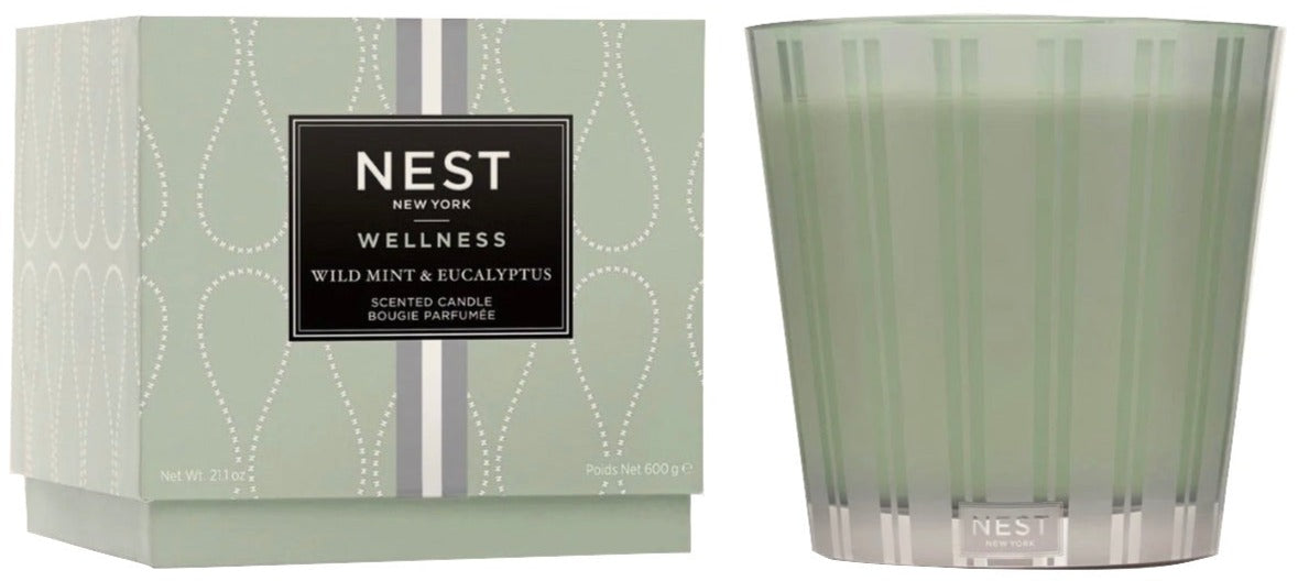 A Nest Wild Mint & Eucalyptus Candle from the Wild Mint & Eucalyptus Candle Collection sits beside its matching light green and silver box, offering an invigorating, spa-like aroma of wild mint and eucalyptus.