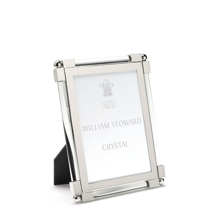 A glass-front Clear Classic Frame from William Yeoward Crystal features a bright nickel-plated finish, displays its label, and stands upright on a black easel back.