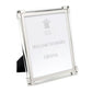 A bright silver photo frame from the Clear Classic Frame Collection by William Yeoward Crystal displays a center placeholder insert with the brand name.