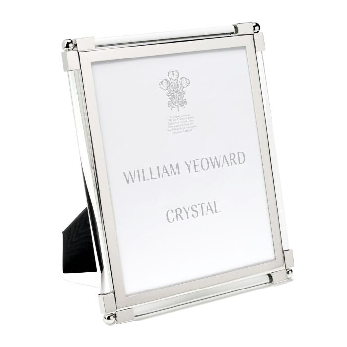 A bright silver photo frame from the Clear Classic Frame Collection by William Yeoward Crystal displays a center placeholder insert with the brand name.