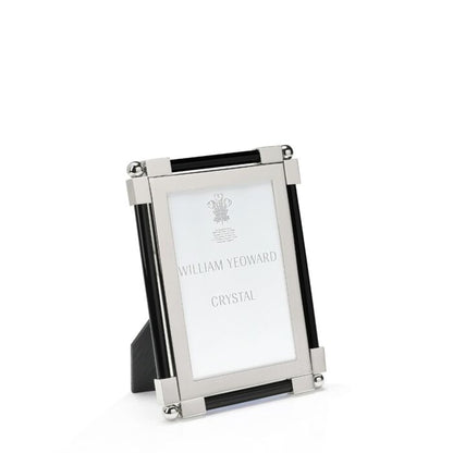 The Black Classic Frame Collection by William Yeoward Crystal features a rectangular nickel-plated metal and glass photo frame with black accents, standing upright. Its bright finish adds a modern touch, and the insert reads "William Yeoward Crystal.