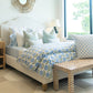 Lee Industries Dome Queen Bed featuring a curved, upholstered headboard, dressed in blue and white floral bedding and patterned throw pillows, with a patterned bench at the foot.