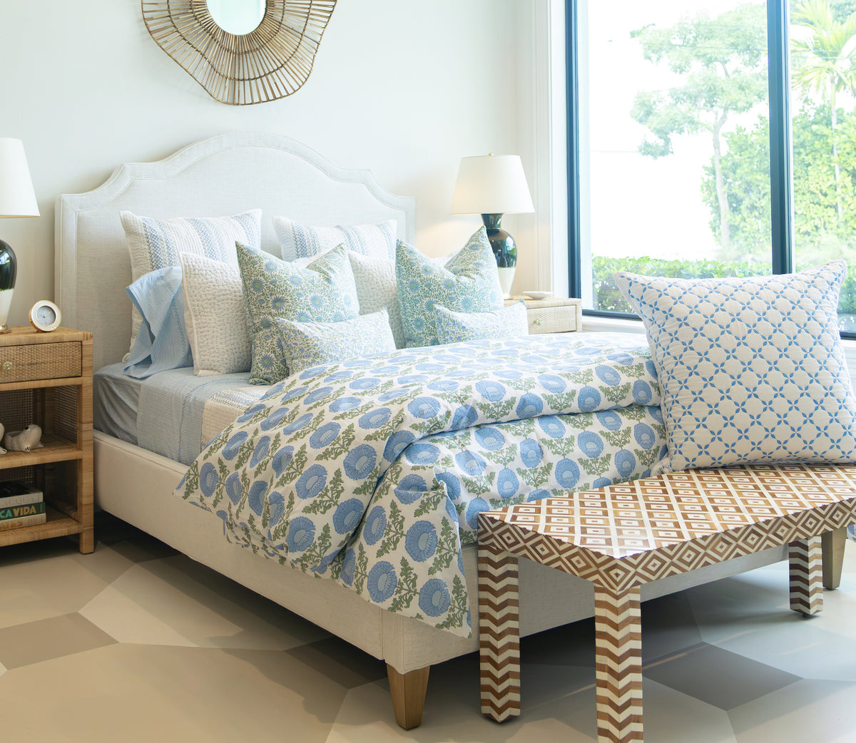 Lee Industries Dome Queen Bed featuring a curved, upholstered headboard, dressed in blue and white floral bedding and patterned throw pillows, with a patterned bench at the foot.